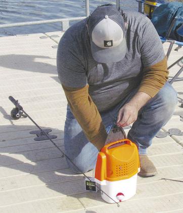 Martin Vela preps his fishing equipment at Acme Brick Park. CDN | Christian Jacobsen