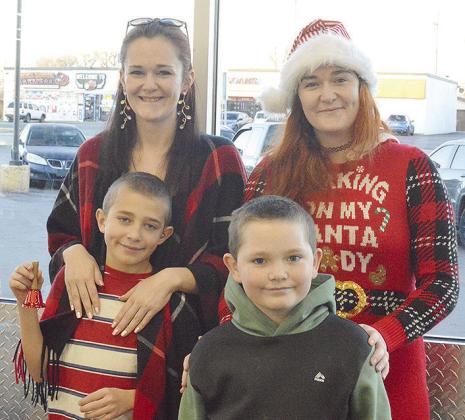 Front left, Lennon Davis, Jasper Faughtenberry; back, Taylor Braswell and Kasie Braswell enjoy the holidays together while ringing the bell to raise money for the Clinton Mission House this Christmas at Homeland.