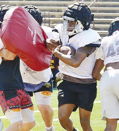 Clinton’s Derren Hester fights through the line of scrimmage carrying the ball during practice in the Tornado Bowl. CDN | Sam Goodwyn