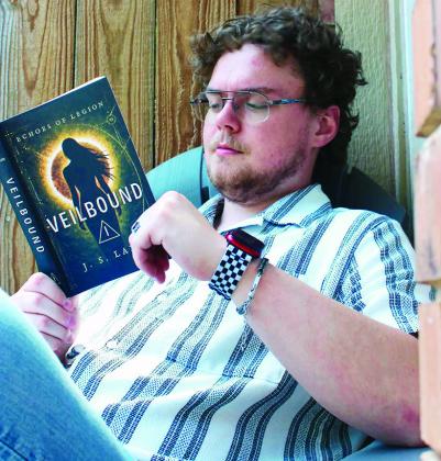 Jeston Laney reads his book “Veilbound” at his home in Weatherford. CDN | Courtesy photo