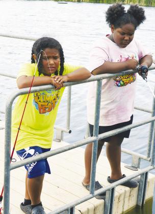 Otha Douglas, left, and Jazzlyn Douglas are trying to fish in a large grouping of blue gill at Acme Brick Park. CDN | Christian Jacobsen