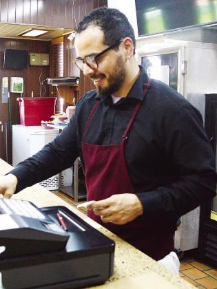 Cesar Lopez checks out a customer behind the register Wednesday evening at the new location for Pedro’s Mexican Food. CDN | Micah Ashcraft