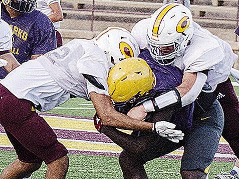Clinton’s CJ Begay, left, and Easten Powell come together to tackle the Anadarko ball carrier during the Red Tornadoes’ scrimmage Friday at the Tornado Bowl. CDN | Sam Goodwyn
