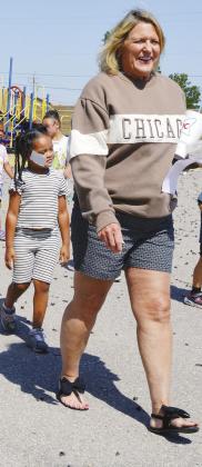 Emeree Adams, left, has her student badge stuck to her face while walking behind kindergarten teacher Carrie Summers for lunch at Nance Elementary. CDN | Christian Jacobsen