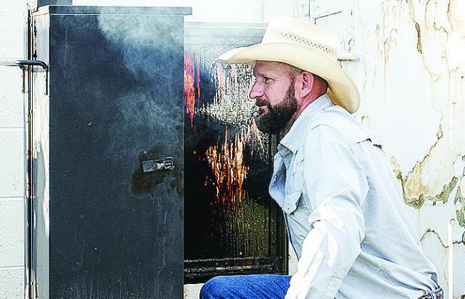 Dave Helch checks on his smoker last weekend during the rodeo at the Clinton Round-Up Club Arena. CDN | Sam Goodwyn