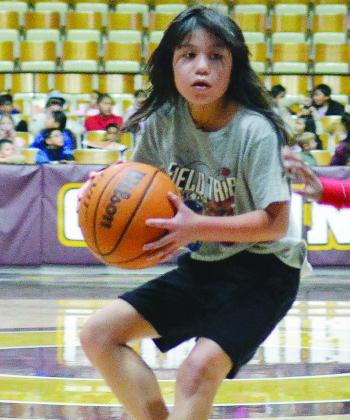Adrianna Lopez keeps hold of the basketball during the second grade’s game in March Madness at the Tornado Dome. CDN |Christian Jacobsen