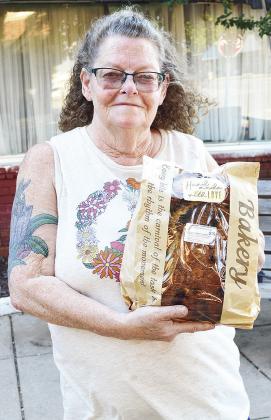 Lori Slagell shows off one of her homemade sourdough bread loaves she had for sale at the Clinton Farmer’s Market Thursday evening at Engleman Park. CDN | Micah Ashcraft