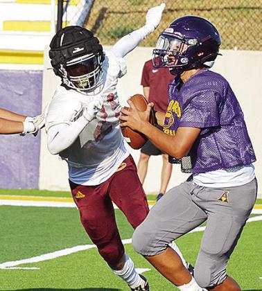 Clinton’s Gavin Evans, left, beats the block around the edge as he hustles toward the quarterback during the Red Tornadoes’ scrimmage Friday in Anadarko. CDN | Sam Goodwyn