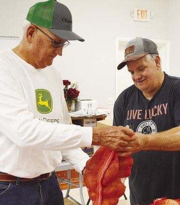 Mission House board member Sam Shelton, left, and Mark Rice check on potatoes delivered to the Mission House food pantry Tuesday morning. CDN | Micah Ashcraft