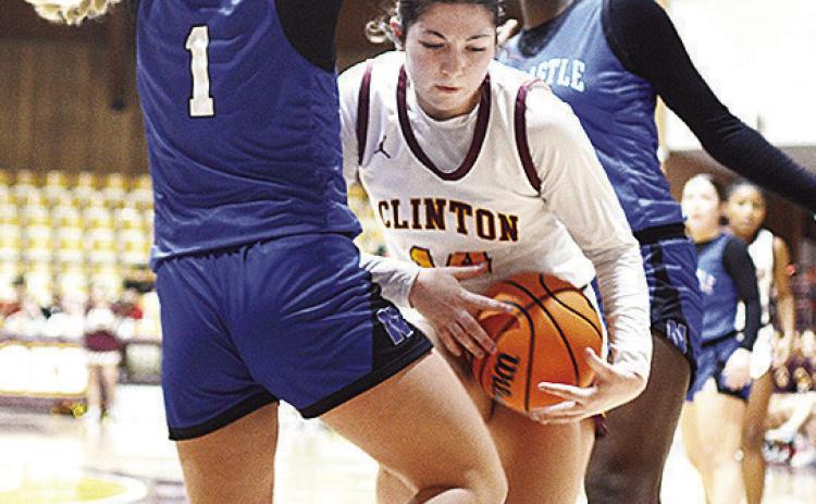 Clinton’s Brooklyn Aston drives between two Newcastle players during the Lady Reds’ home game Thursday against the Lady Racers. CDN | Sam Goodwyn