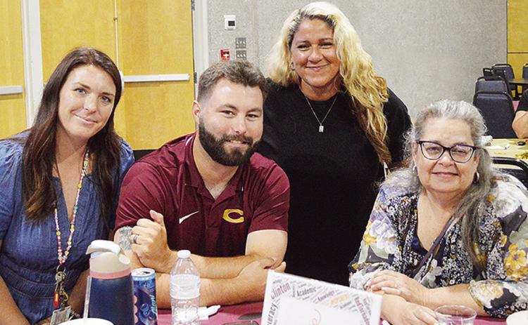 From left, Clinton Middle School math teacher Sarah Kerr, history teacher Robert Gordon, discretionary assistant Micah Williams, and Clinton High School librarian Christy Manhart share a table at the Clinton Public Schools’ all-staff gathering Wednesday