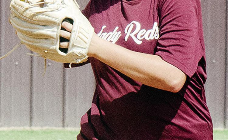 Clinton’s Sydnee Pugh transfers the ball to her hand as she prepares to throw the ball during softball practice. CDN |Sam Goodwyn