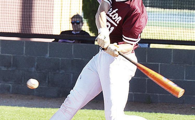Clinton’s Ayden Crumley focuses on the ball as he swings the bat during the Reds’ home game against Okarche. CDN | Sam Goodwyn