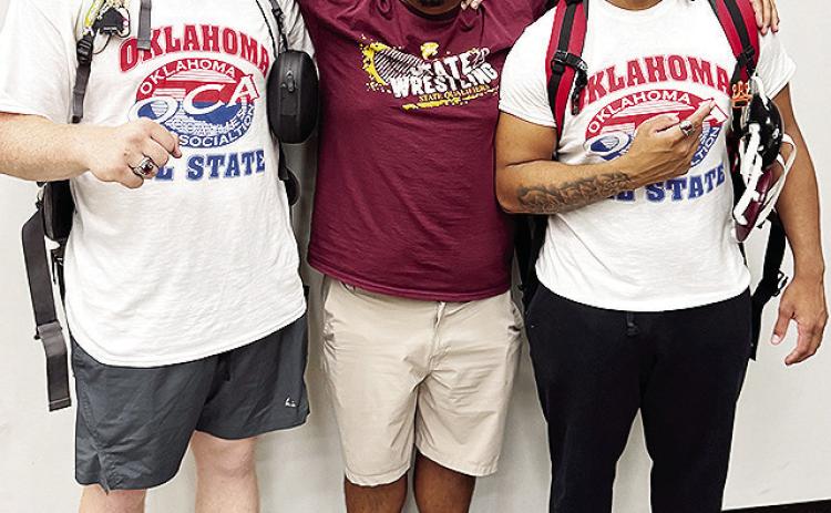 Malachi Lorne, right, celebrates with teammate Marcus Wilson, left, and Clinton wrestling assistant coach Josue Martinez after his bout Wednesday in the All-State wrestling match in Catoosa. CDN | Courtesy photo