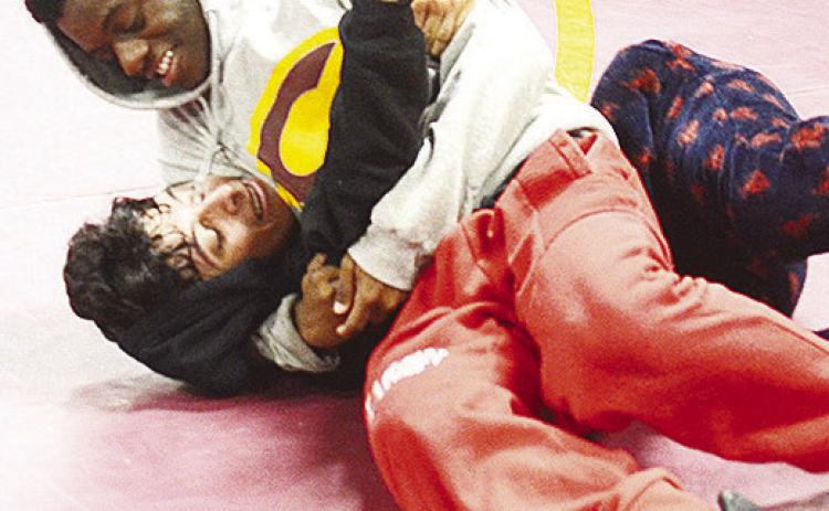 Clinton’s Marquis Martin, top, pins teammate Mathew Bermea to the mat during practice. CDN | Sam Goodwyn