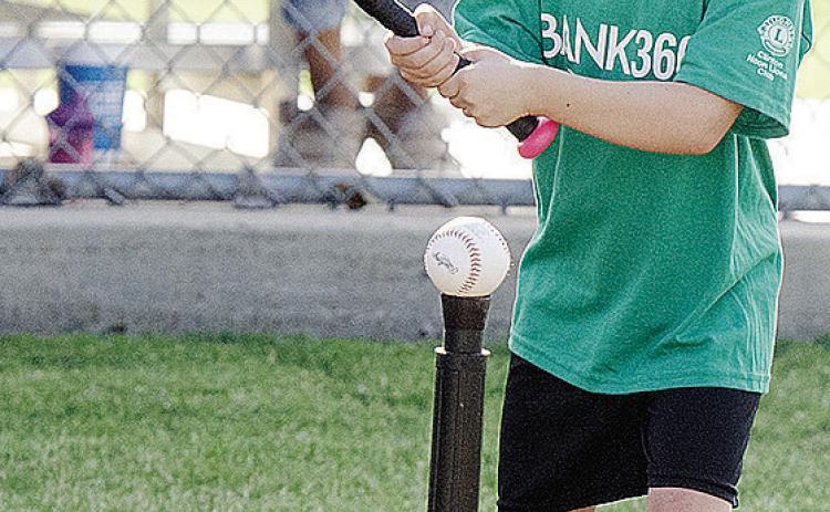 Kezli Cox focuses on the ball as she goes into her swing during her Noon Lion’s Club T-Ball game at Schumacher Fields at Acme Brick Park CDN |Sam Goodwyn