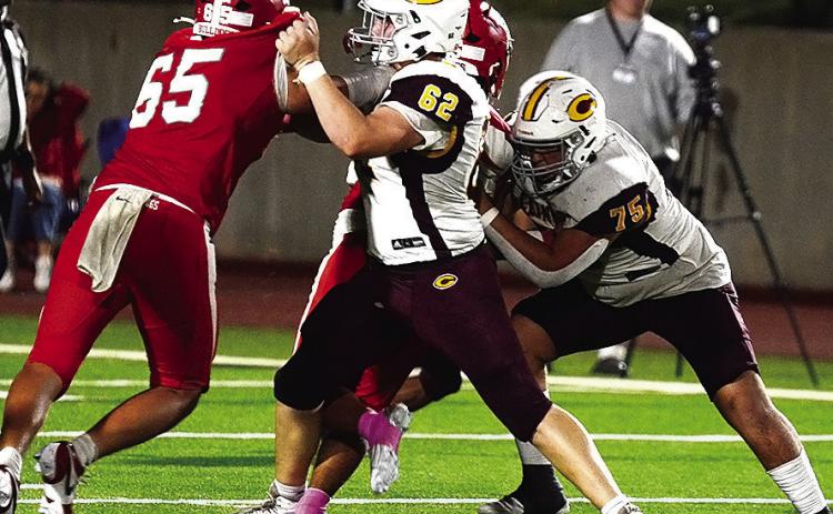 Clinton’s No. 62 Layne Spitz and No. 75 Eli Anderson block Cache defenders during the Red Tornadoes’ road game Thursday against the Bulldogs. CDN | Micah Ashcraft