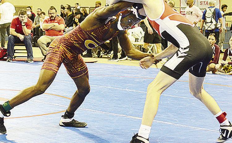 Clinton’s Marquis Martin, left, grapples with his opponent during the consolation bracket of the 4A State Wrestling Tournament Saturday at the Jim Norick Arena in Oklahoma City. CDN | Sam Goodwyn