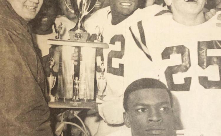 The Clinton Red Tornadoes pose with the Class A State football trophy, won by besting Wewoka 42-6 Friday night. Head coach Jim Frazier, left, grasps the trophy while, left to right from trophy, James Williams, E.L. Jefferson, Myron Hines and Chuck Powell