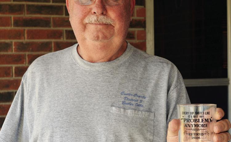 Randy Kelley shows off his new gifted retirement glass. The text reads, “Every sip tastes like it’s not my problem anymore. Retired 2026.” CDN | Christian Jacobsen