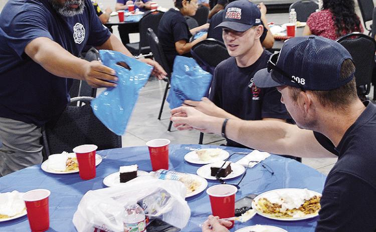 From left, Emergency Management Dir. Charles Black hands out goodie bags to Colten Helms, and Lt. Billy Gerstenkorn Monday at the Hometown Heroes Luncheon hosted by Lucky Star Casino at the Frisco Center. CDN | Christian Jacobsen