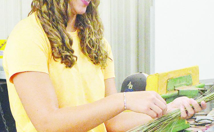 Arapaho-Butler’s Georgia Rose works to bundle together straws of grass during her agriculture class Monday morning. CDN | Micah Ashcraft