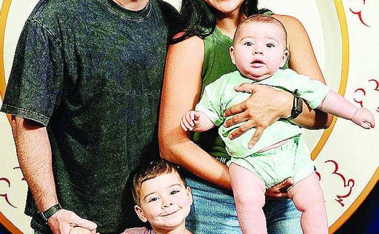 Newly hired Clinton boys’ wrestling coach Matt Kennedy, left, holds his son Koe’s hand, and his wife Denise, right, holds their infant Cub while at Disney. CDN | Courtesy photo