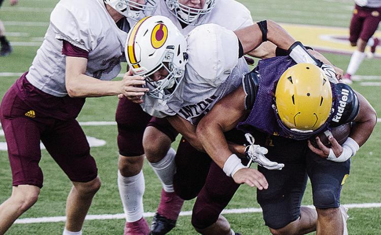 Clinton’s JJ Ruiz, front, wraps up the Anadarko ball carrier with help from Judd Hall, left, and Easten Powell, back, during the Red Tornadoes’ scrimmage against Anadarko. CDN | Sam Goodwyn