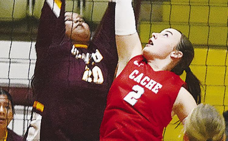 Clinton’s Aracelie Chavez, left, goes up to block a Cache player during the Lady Reds’ match against the Lady Bulldogs at the Tornado Dome. CDN | Sam Goodwyn