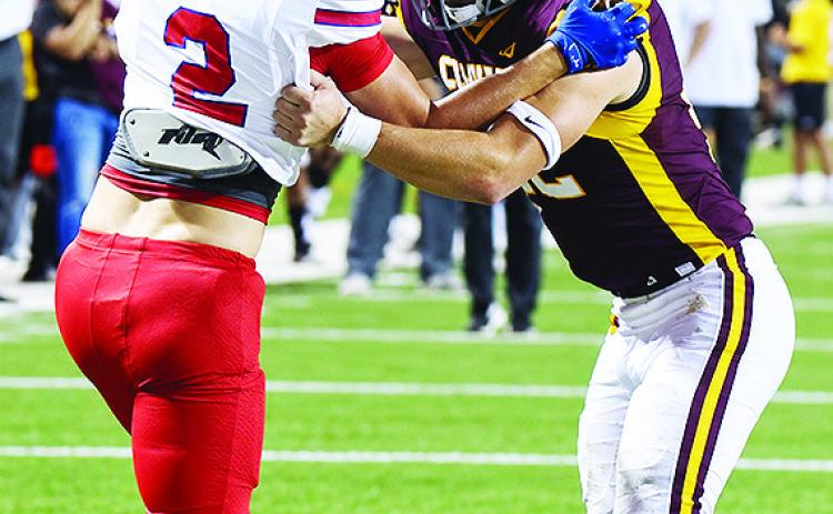 Clinton’s Benton Bridgeman blocks a Durant defender during the Red Tornadoes’ come-from-behind win over the Lions last week in the Tornado Bowl. CDN | John Kinsey