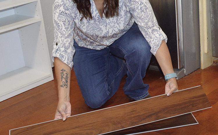 Renee Johnson, director of Kingdom Kids Daycare, shows the new flooring panels that will be installed where the kitchen island used to be located. CDN | Christian Jacobsen