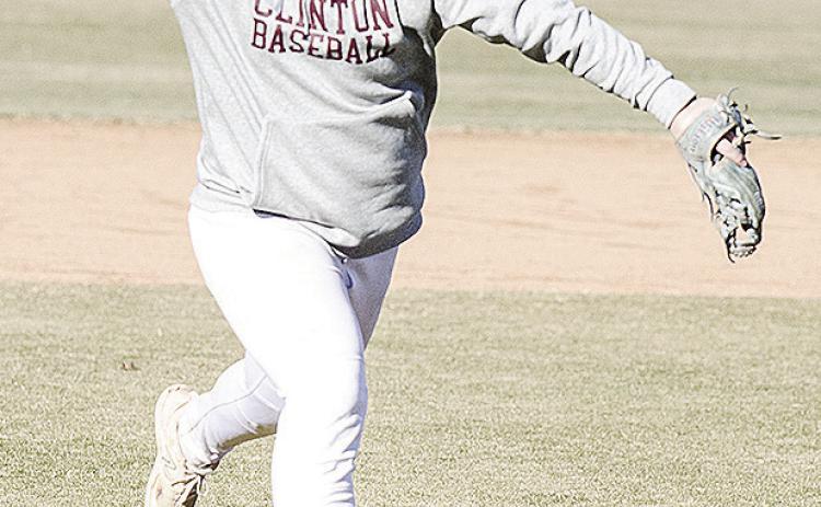 CDN | Sam Goodwyn Clinton’s Trason Lustfield hurls the ball to first for the out during practice at the baseball field.