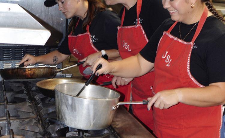 From left, Junior Service League members Shawna Hardin, Erin Giles, and Stacie Nickel practice their sauce making Saturday at the Frisco Center kitchen. The JSL Spaghetti Dinner will be available Friday for lunch and dinner. CDN | Christian Jacobsen