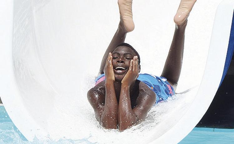 Tylain Rainge is all smiles as he rides the down the water slide Wednesday at the Clinton Municipal Pool. The pool will be closing soon. CDN | Sam Goodwyn