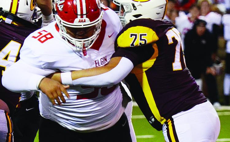 Clinton’s No. 75 Eli Anderson blocks the Elgin defender during the Red Tornadoes’ homecoming game Friday against the Owls in the Tornado Bowl. CDN | Micah Ashcraft