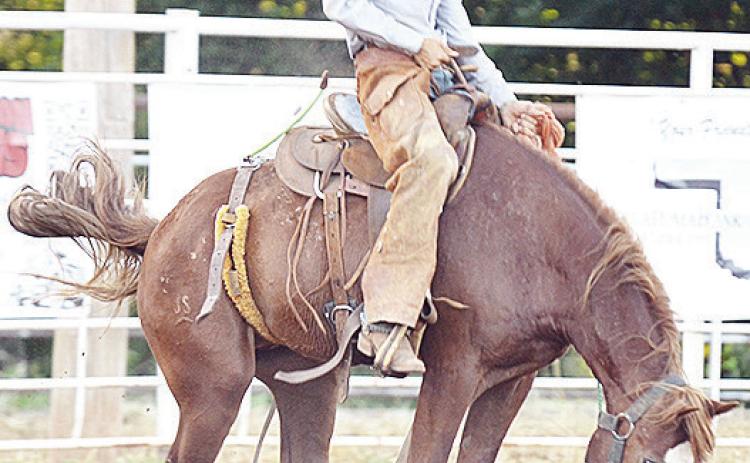 Wyatt Graves holds onto his horse as he loses his hat in the saddle bronc riding event Saturday during the Clinton Roundup Club’s 78th Annual Rodeo. CDN | Sam Goodwyn