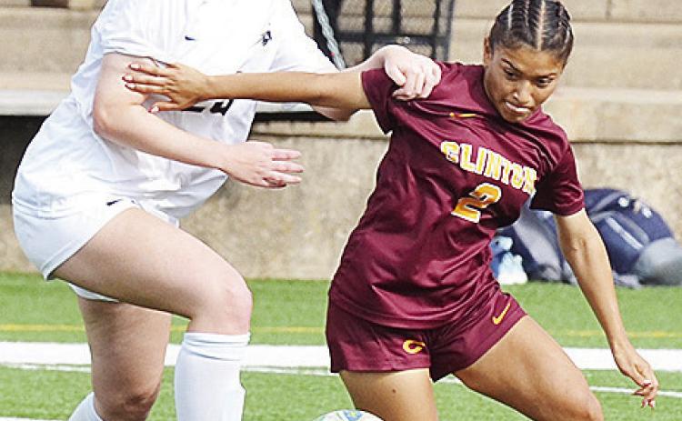 Clinton’s No. 2 Sammy Meraz fights a Heritage Hall defender for the ball during the Lady Reds’ home game Monday against the Lady Chargers. CDN | Sam Goodwyn