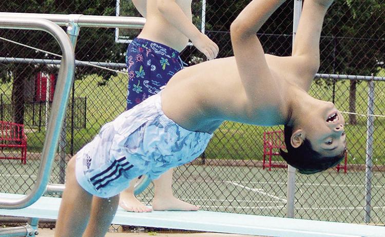 Juan Martinez tries to perform a backflip into the water Thursday at the Clinton Pool during Summer Playground. CDN | Christian Jacobsen