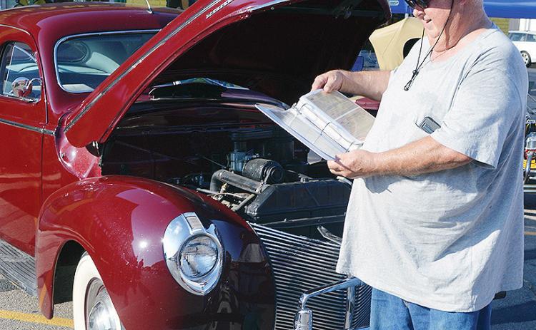 Orval Williams shows off the documentation of all the vehicle registrations for his 1940 Mercury 8 Saturday at the Centennial Lap event on Frisco Avenue. More pictures from the event are on page 16. CDN | Christian Jacobsen