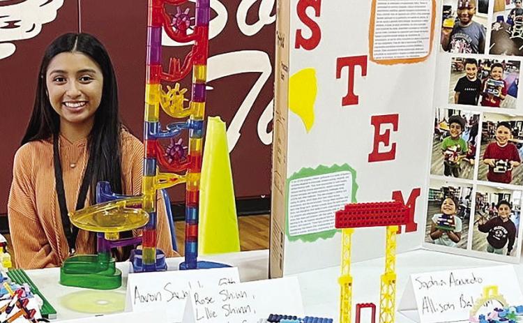 Joanna Venegas shows off several student STEM-based projects to better convey the value in the Clinton Public School’s REDS 365 program to community members at Southwest Elementary. CDN | Courtesy photo
