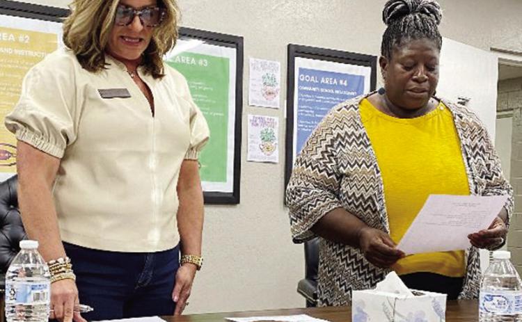 Clinton School Board President Kim Meacham, left, administers the board of education oath to Luzella Williams, as she attends her first official meeting Thursday. CDN | Staff Photo