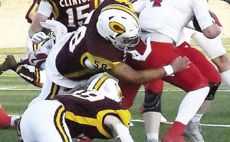 Clinton’s No. 58 Ares Gallegos takes down the Durant ball carrier while No. 19 Dyson Moss and No. 15 Gavin Evans come to help during the Red Tornadoes’ come-from-behind win Friday in the Tornado Bowl. CDN | John Kinsey