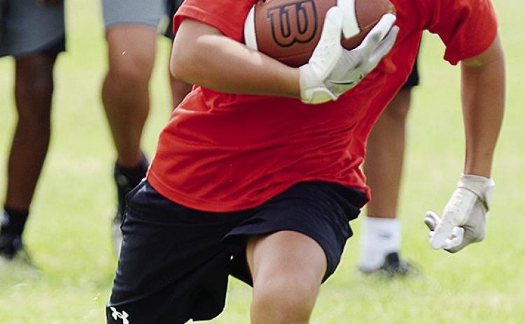 BentLee Potter carries the ball during the first day of football practice for the Whirlwinds Monday at Clinton Middle School. CDN | Sam Goodwyn