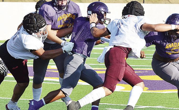 Clinton’s Alex Amaya, left, and Easten Powell fight through blocks as they try to take down the ball carrier during the Red Tornadoes scrimmage Friday in Anadarko. CDN | Sam Goodwyn