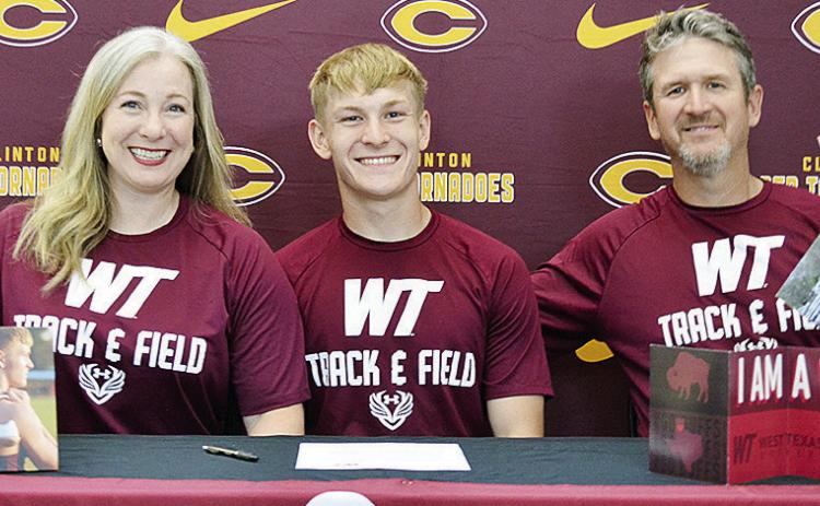 Clinton Red Tornadoes’ track and field athlete Parker Adams, center, is all smiles after signing to compete for the West Texas A&amp;M Buffaloes. He celebrates the signing with his mother Erin, left, and father Luke, right, by his side. CDN | Sam Goodwy