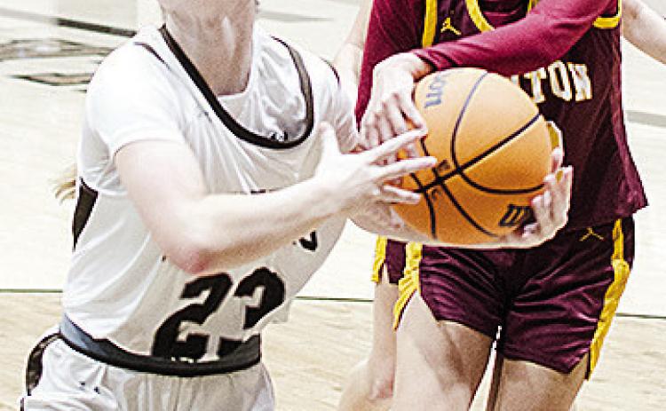 Clinton’s Rihanna Ellis, right, grabs onto the ball as the Elk City player attempts to drive past her Tuesday during the Lady Reds’ road game. CDN | Sam Goodwyn