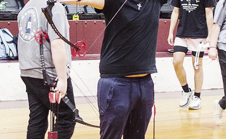 Clinton’s Jaeden Tortoledo aims his bow as he prepares to fire during archery practice Wednesday at the old Clinton Middle School Gym. CDN | Sam Goodwyn