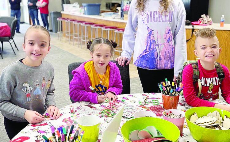 From left, Hazel Kauk, Claire Kreizenbeck, Audrey Kauk, and Maverick Kauk make Christmas-themed crafts during the annual Custer County 4-H Santa’s Workshop. CDN | Courtesy photo
