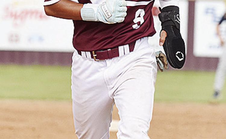 Clinton’s Azreal Fierros hustles to third during the Reds’ home game against Kingfisher. CDN | Sam Goodwyn