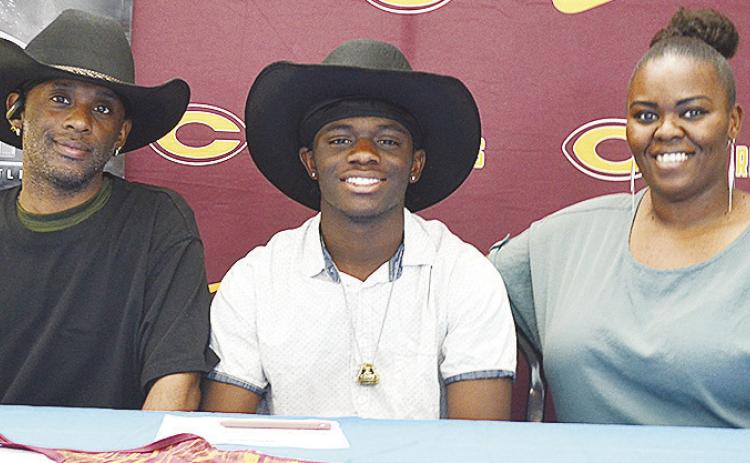 Clinton’s Marquis Martin is all smiles as he celebrates signing to wrestle for Northeastern A&amp;M College in Miami with his father, Marquis Martin Sr., left, and his mother, Marcelle Martin, right. CDN | Sam Goodwyn